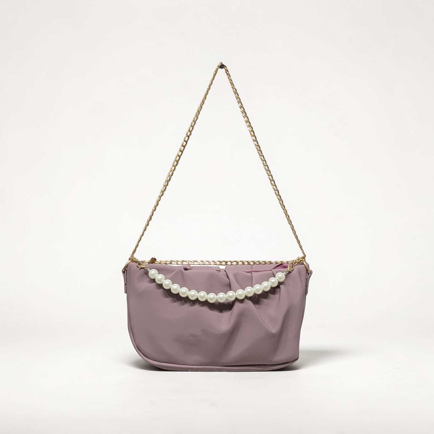 Purple handbag with pearl embellishments on a light gray background