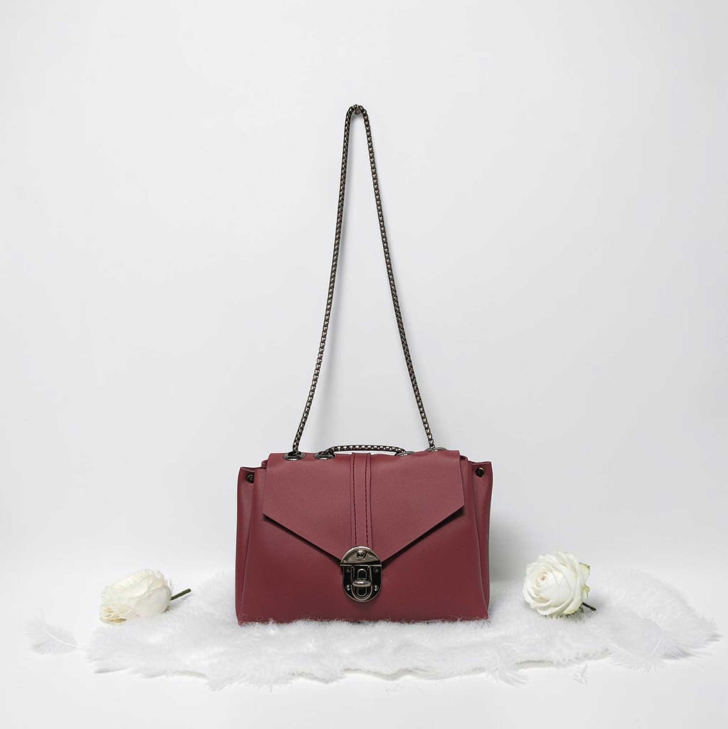 Pink handbag with a chain strap on a white background