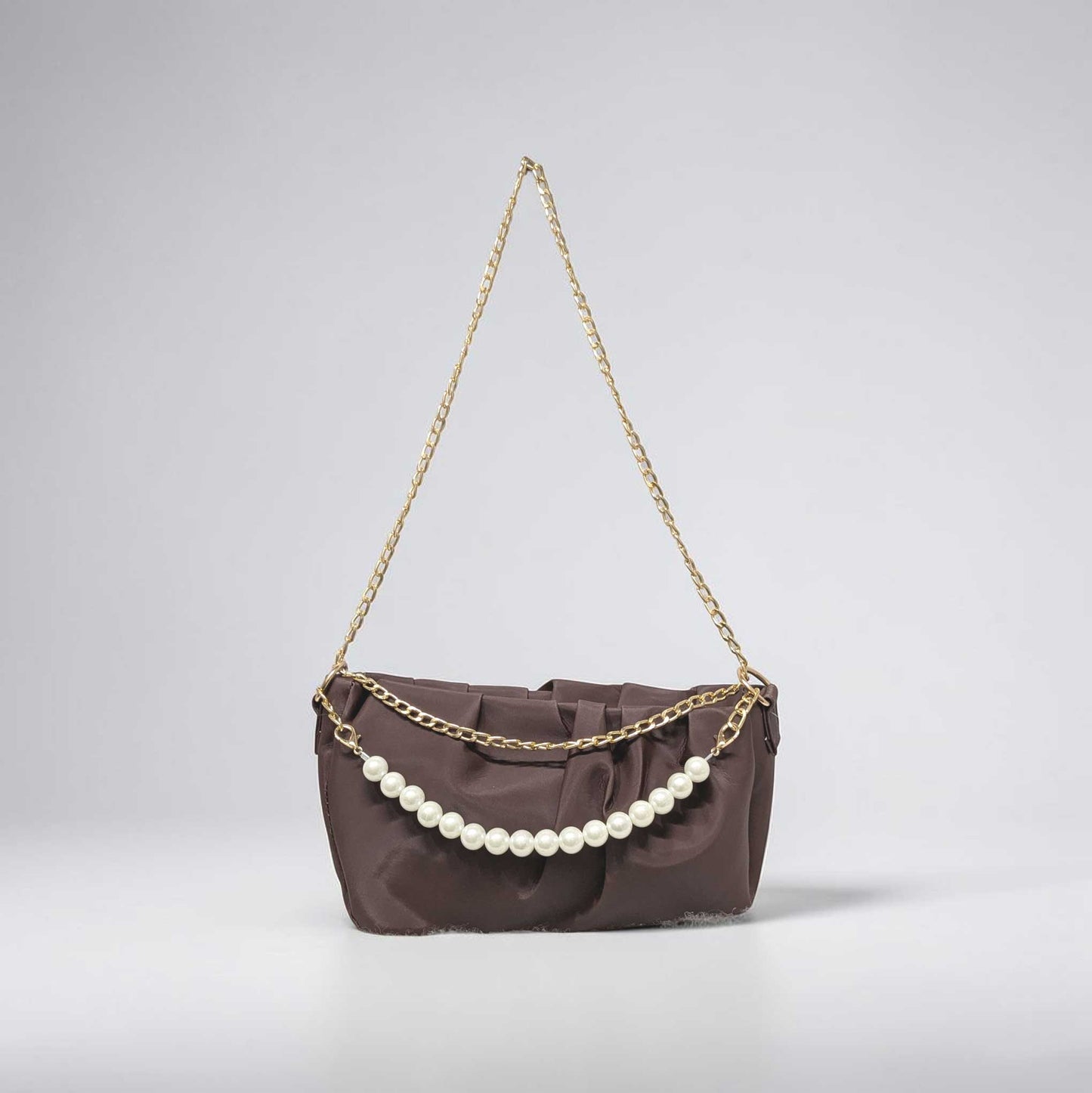 Brown handbag with a gold chain and pearl embellishments on a light gray background